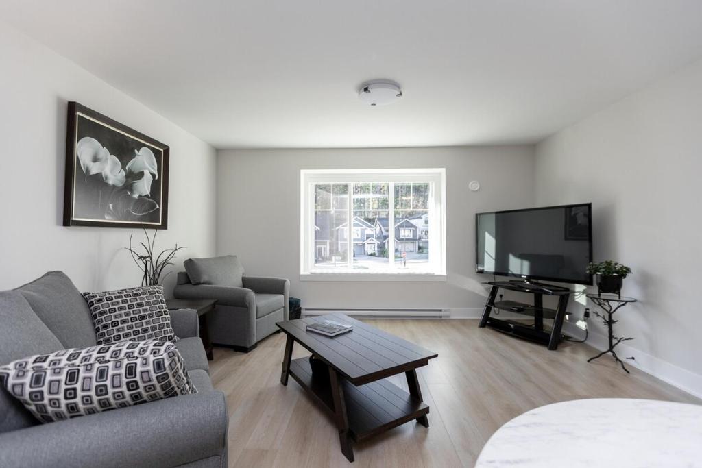 a living room with a couch and a tv at Cozy Corner on Trumpeter in Colwood