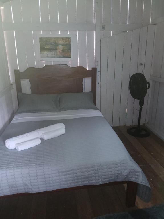 a bedroom with a bed with two towels on it at Hospedagem coqueiros in Soure