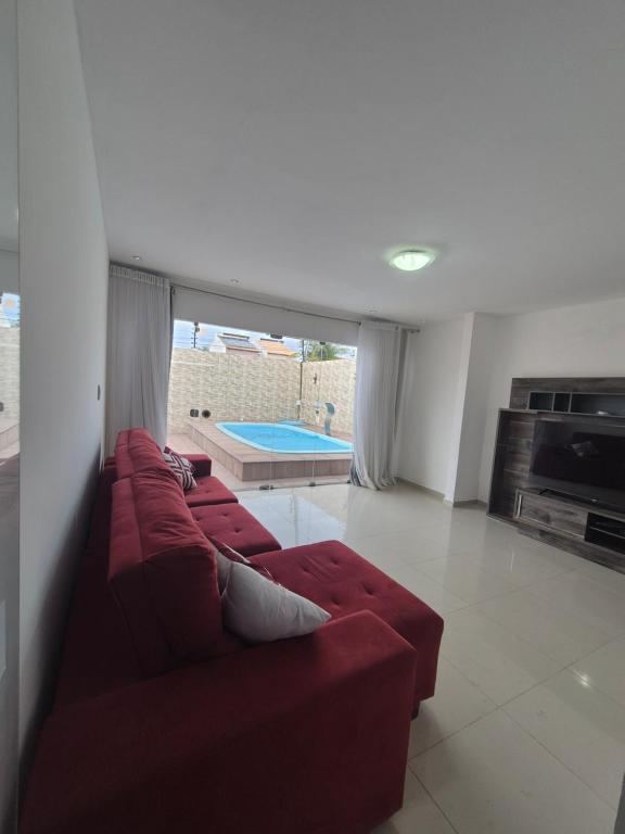 a living room with a red couch and a pool at Casa com piscina in Petrolina
