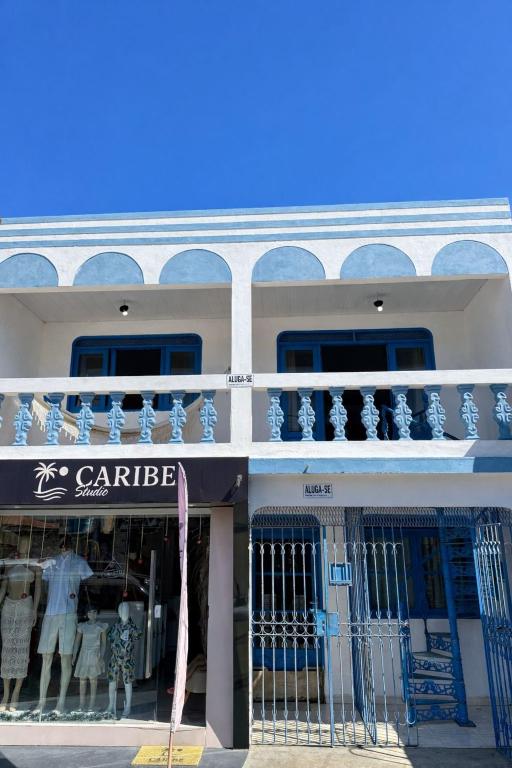a white building with blue windows and a balcony at CASA MARAGOGI 3 Quartos in Maragogi