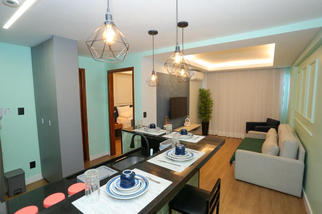 a living room with a dining table and a couch at Flat Rosarinho - Confortável e Super Completo in Recife