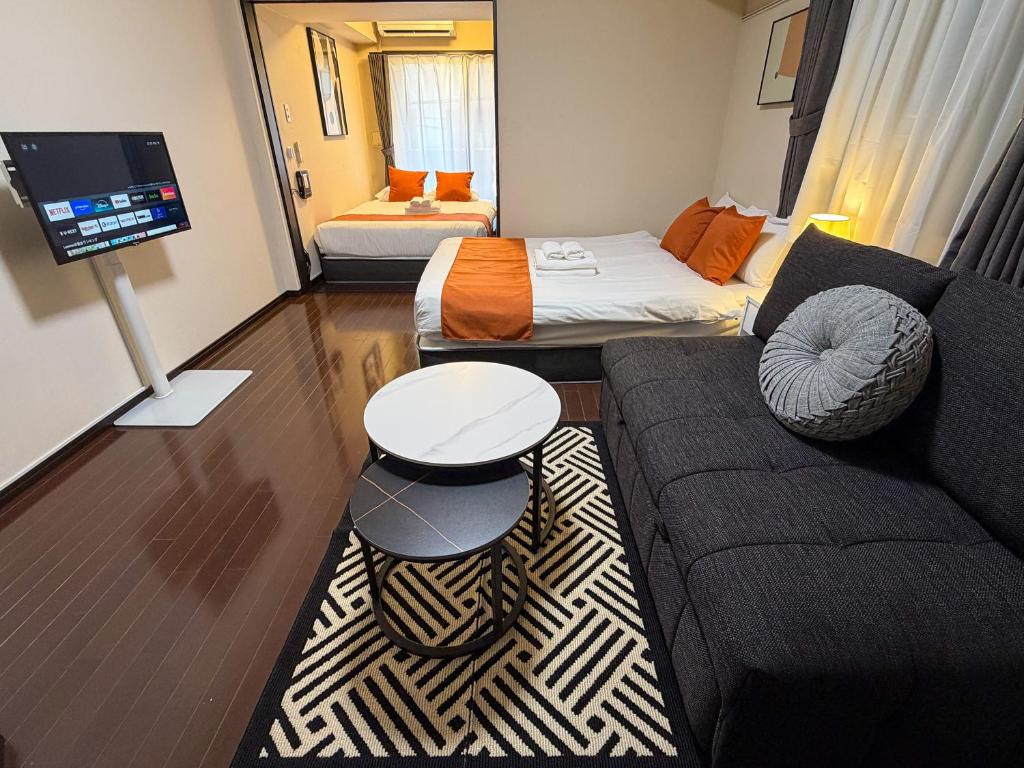 a living room with a couch and a bed at BALCOM STAY Hiroshima Otemachi in Hiroshima