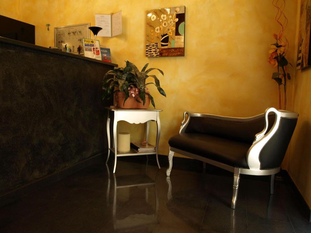 ein Wohnzimmer mit einem Stuhl und einem Tisch in der Unterkunft Hotel Karol in Monza