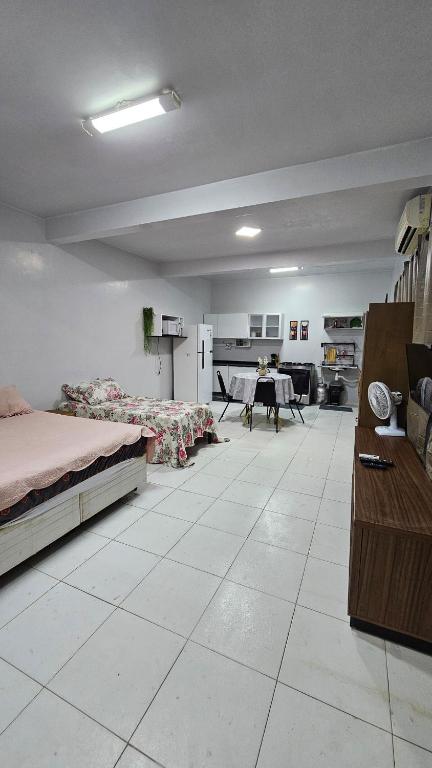 a large room with a bed and a dining room at Estúdio Completo in Marabá