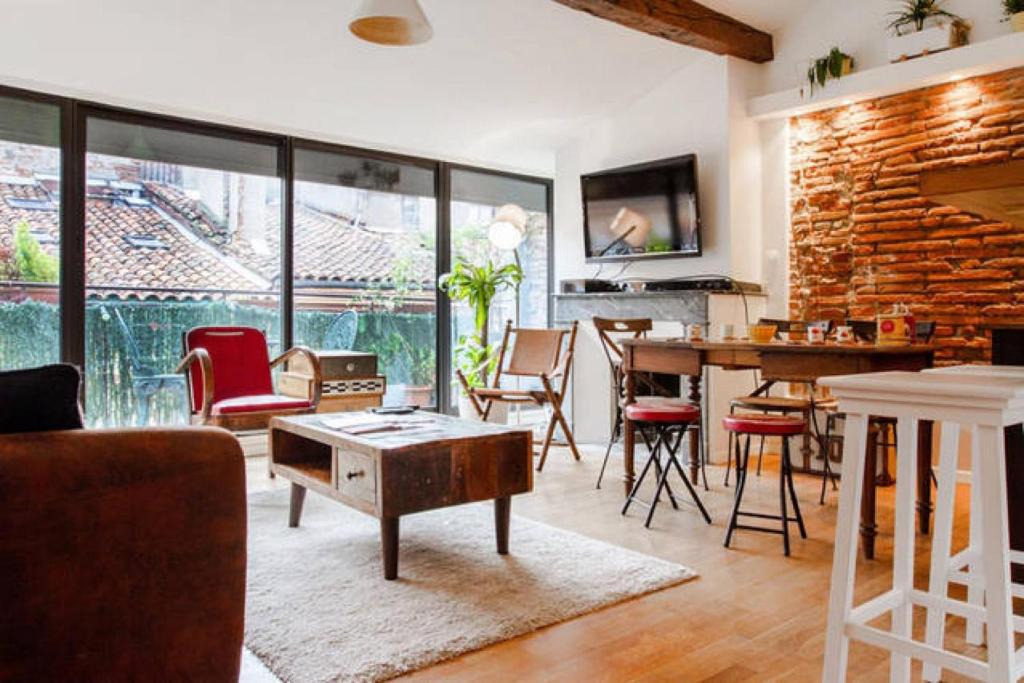 a living room with a table and chairs at Loft 9 Rue Fermat in Toulouse