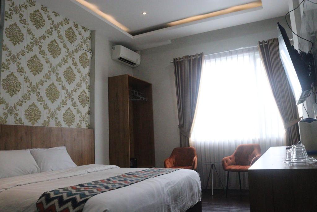 a hotel room with a bed and a window at Edu HOTEL Y-SKANAM SYARIAH in Surabaya