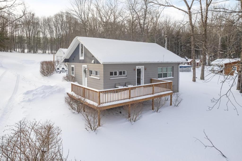 a house with a deck in the snow at Ballers Bungalow by Railey Vacations in Swanton