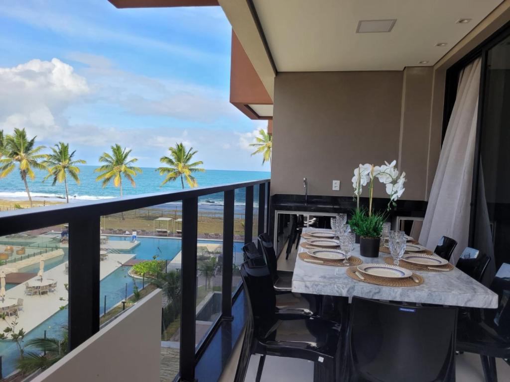 a dining room with a table and a view of the ocean at Resort Cais Eco Residence in Ipojuca
