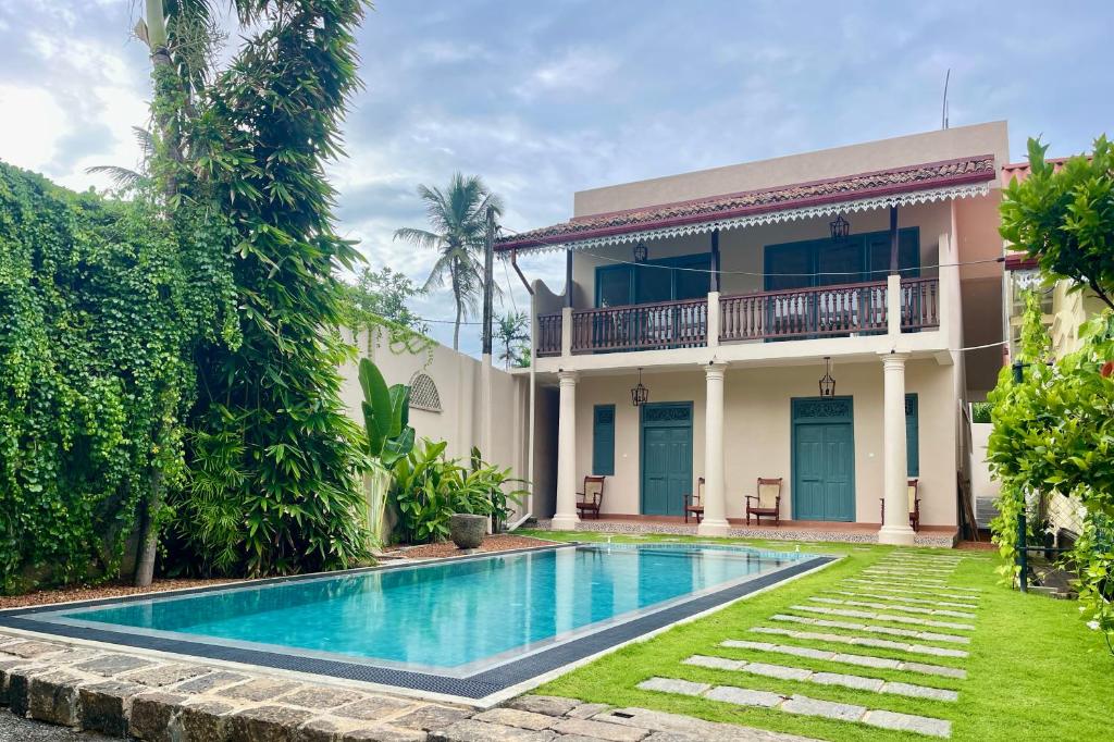 a villa with a swimming pool in front of a house at Villa Sethoskai -100m to Beach in Ambalangoda