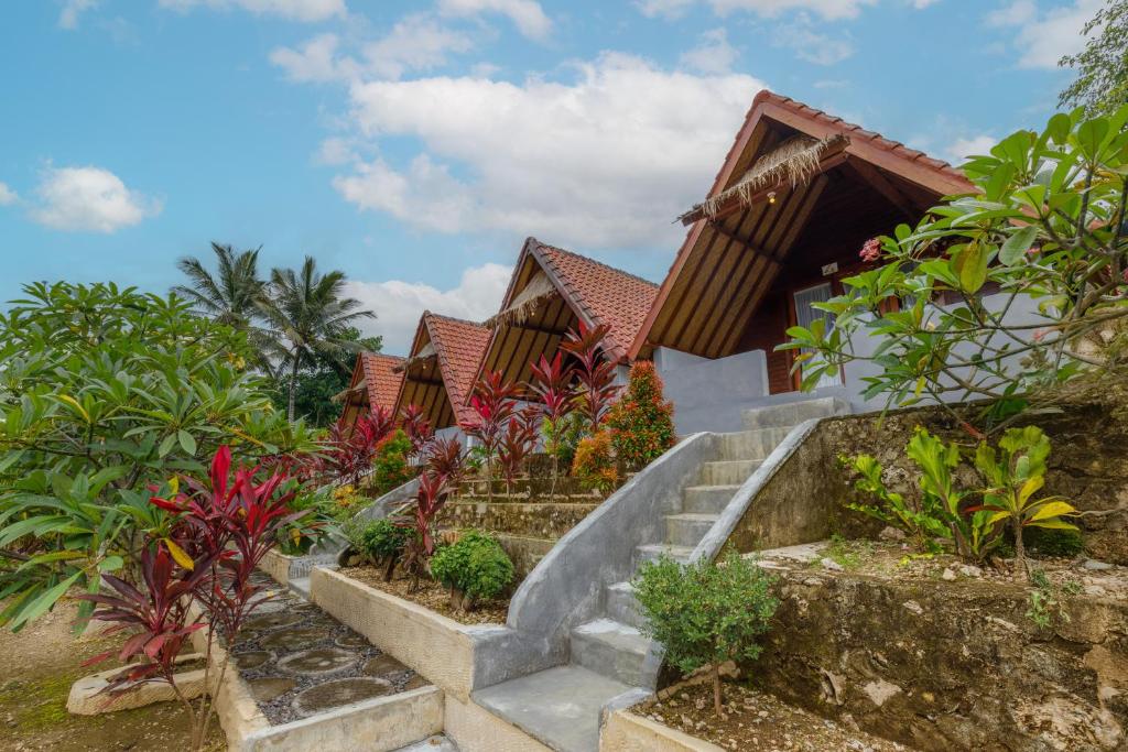 a resort with a staircase leading up to a house at La Rise Penida Cottage in Nusa Penida
