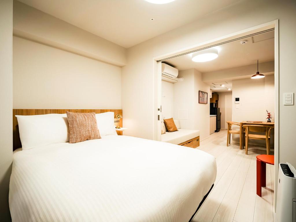 a bedroom with a white bed and a dining room at Section L Akihabara in Tokyo