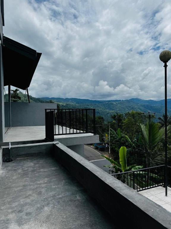 a balcony of a house with a view of the mountains at ARHH castle in Ginigathena