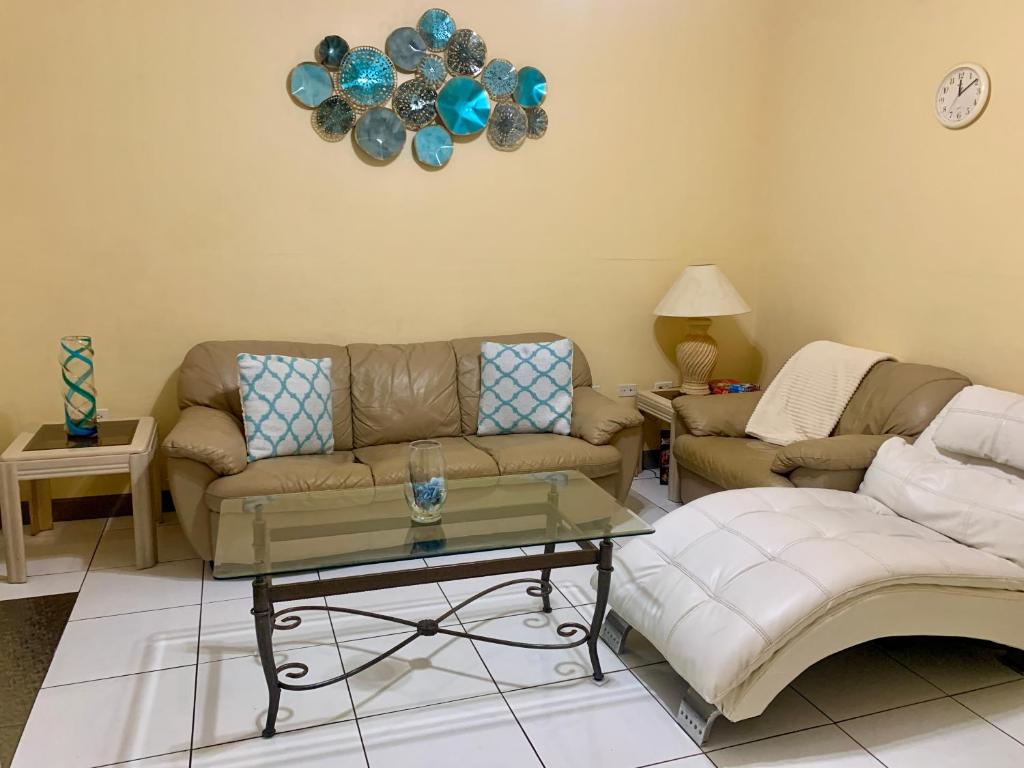 a living room with two couches and a table at SUITE 2, BLUE PAVILION - Steps to BEACH in West Bay