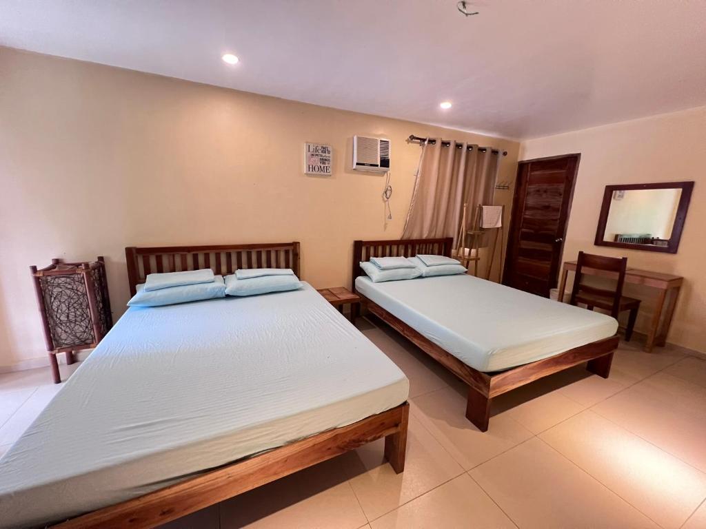 a bedroom with two beds in a room at Boracay Amor Apartment (Garden) in Boracay