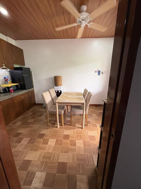 a kitchen with a table and chairs and a ceiling fan at Sonnenblume Homestay in General Luna