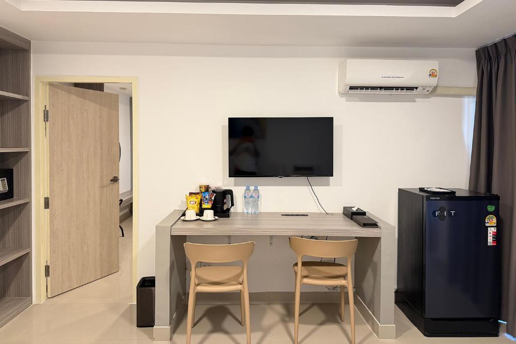 The room’s compact work-and-refreshment station sits beneath the television.