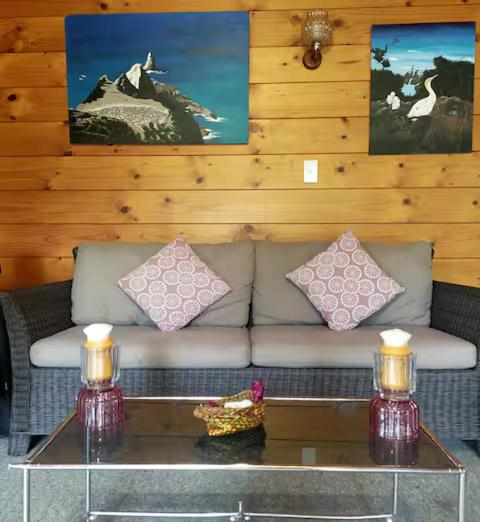 a couch with two pillows and a table in a living room at Steve's Cozy Retreat in Taupo