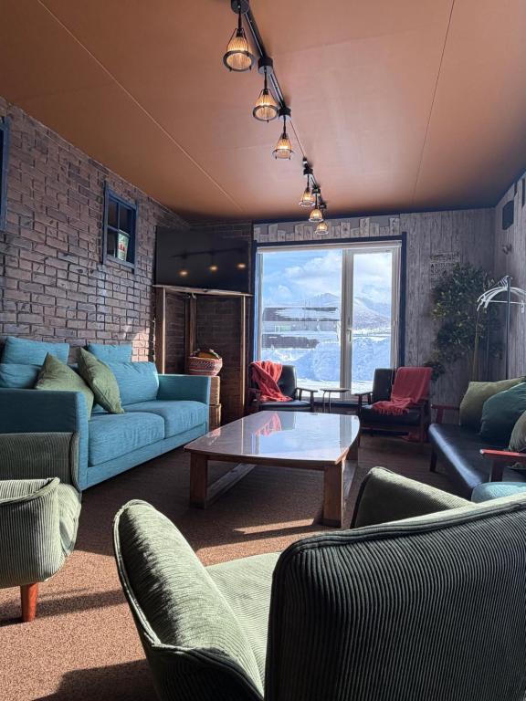a living room with couches and a table at ルスツリゾート車5分大人数向け貸別荘RusutsuSkiStay111BBQ無料貸し出し花火OK in Rusutsu