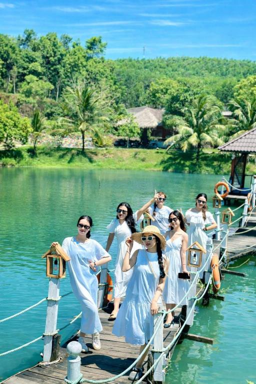 a group of people standing on a dock in the water at Đồi Dẻ Eco HomeStay in Bố Trạch