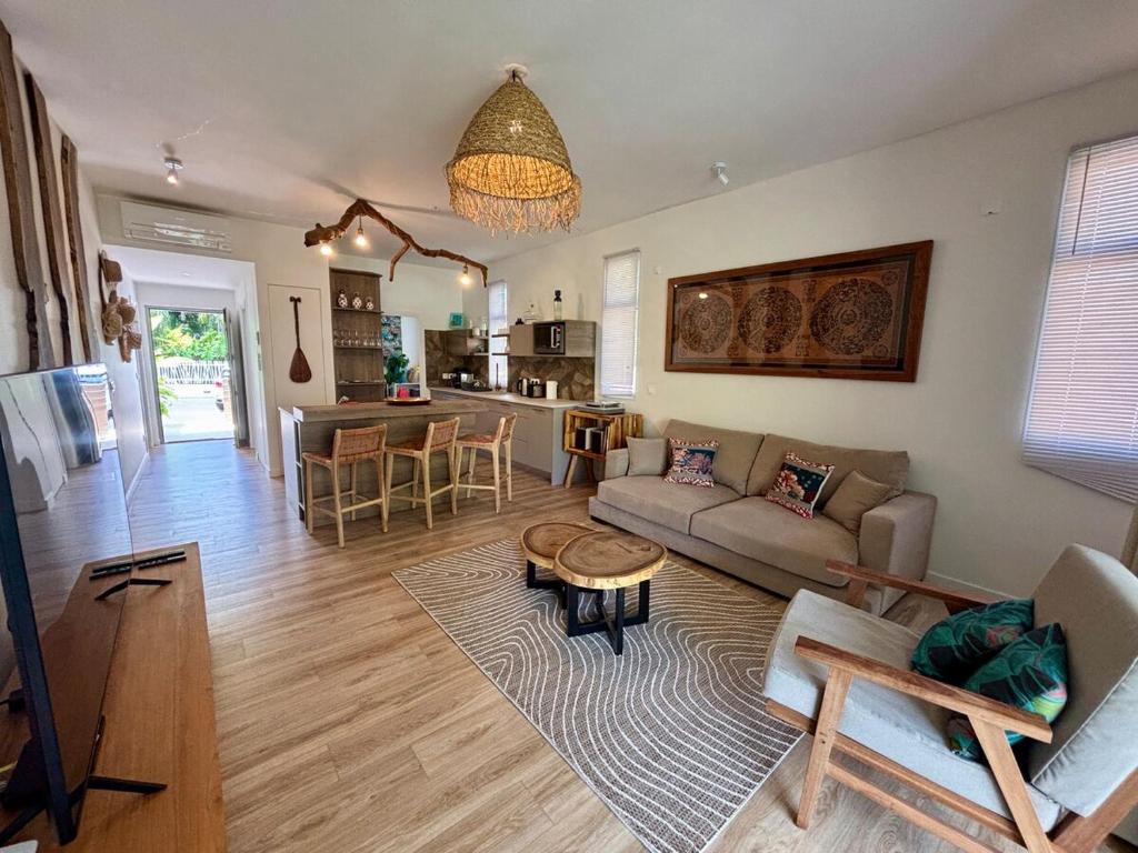 a living room with a couch and a table at Te mana Dream apartment in Paea