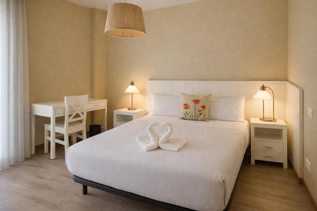 a bedroom with a large white bed with two white bows at AYZ Villegas - Auto check-in property in Madrid
