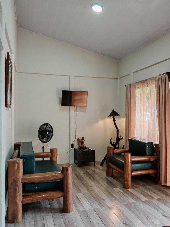 a living room with two chairs and a television at Villa Tucano in Fortuna