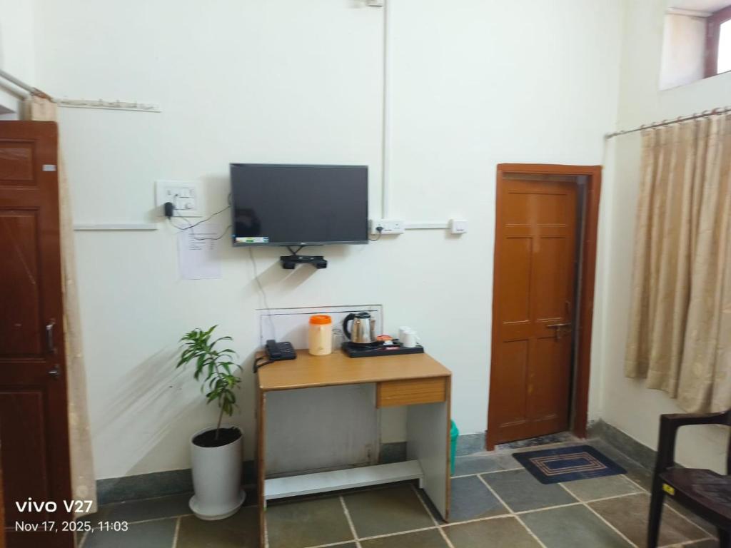 a room with a desk with a tv on a wall at Riddhi Guest House in Udaipur
