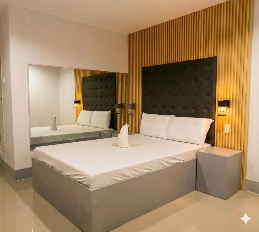 a bedroom with two beds and a headboard at D New Inn Mactan in Lapu Lapu City