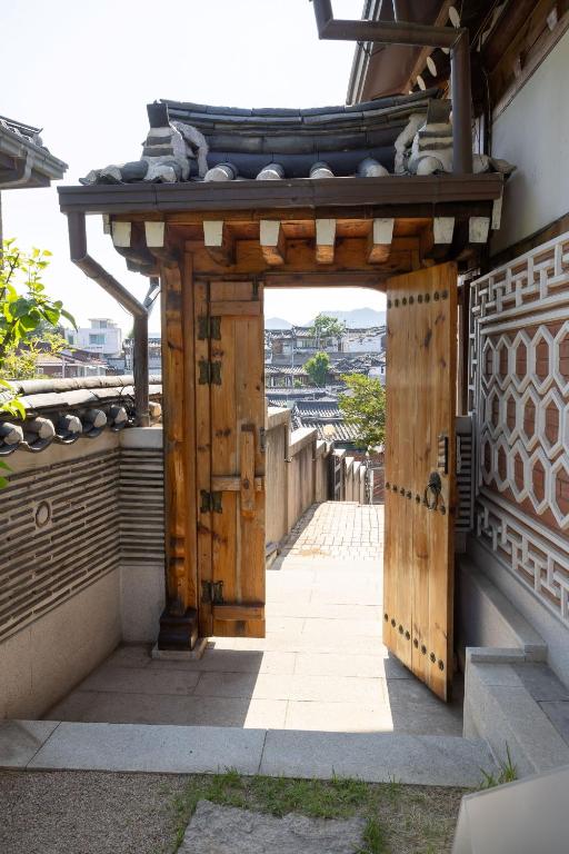 an entrance to a building with a wooden door at HakMinJae Hanok Stay in Seoul