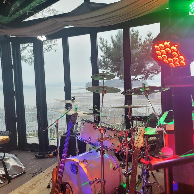 a drum set sitting in a room with a window at Seosan View Live in Seosan