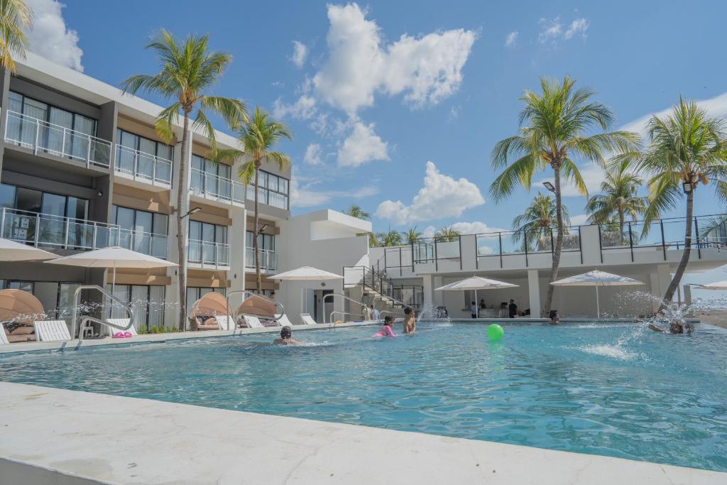 a swimming pool at a resort with palm trees at Coco Blue a New Beach Resort in La Libertad