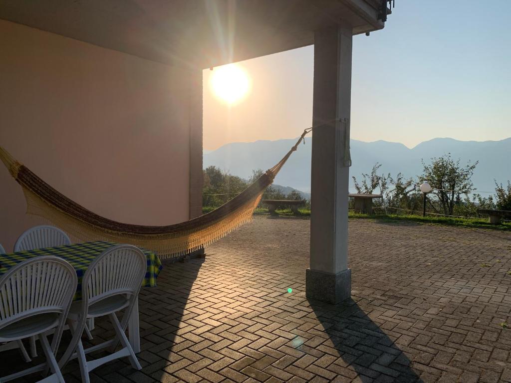a hammock on a patio with a view of the mountains at Casa Vacanze a Luino - Casa di Adele in Luino