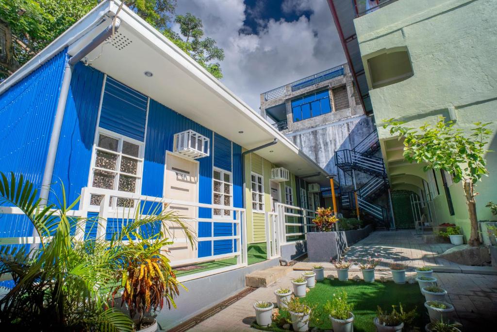 a blue building with plants in front of it at Liberty's Homestay Private Apartment in Coron