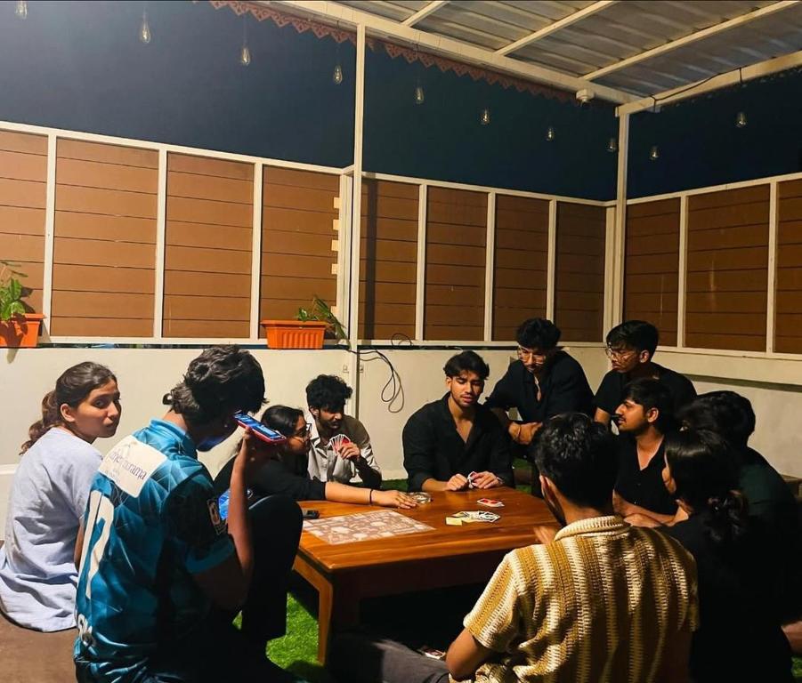 a group of people sitting around a table at BUNK HUB hostel in Pondicherry