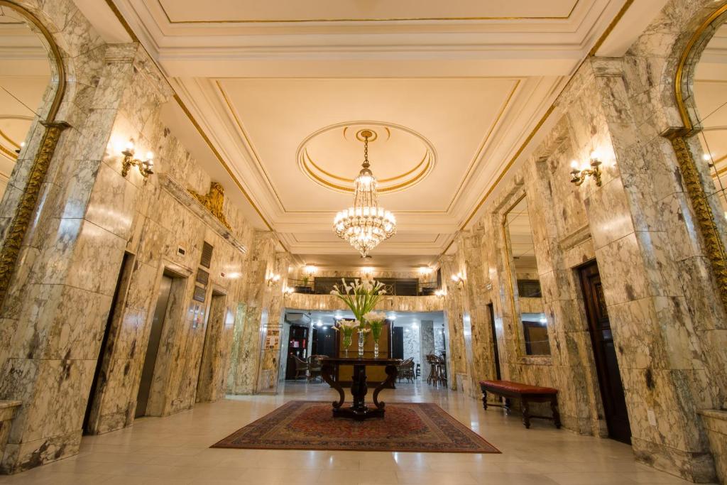 a hallway with marble walls and a chandelier at Hotel OK in Rio de Janeiro