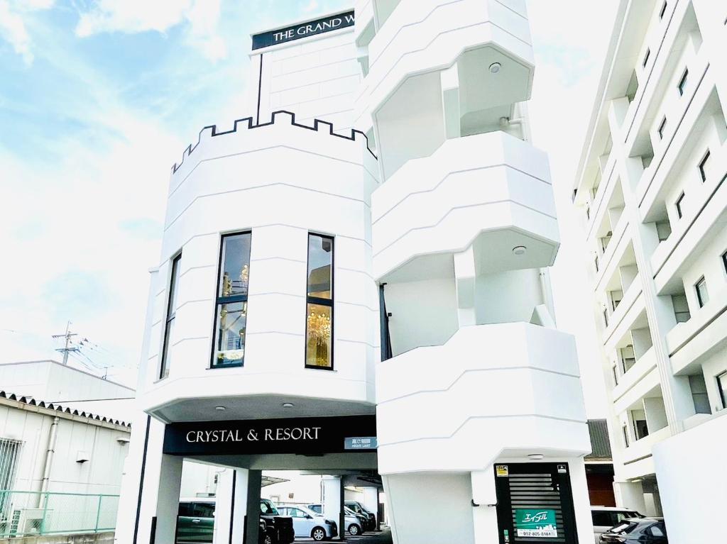a white building with a sign in front of it at The Grand Win in Fukuoka