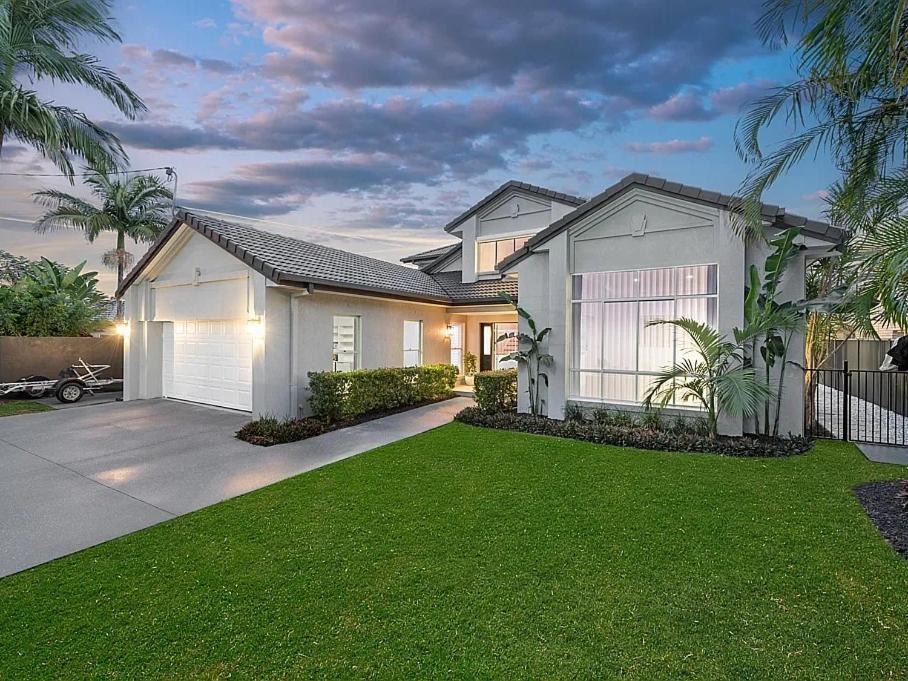 a large white house with a grass yard at Capri Garden Stay in Gold Coast