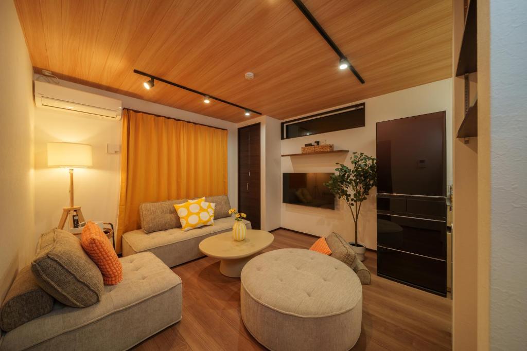 a living room with a couch and a table at LilyHouse in Beppu