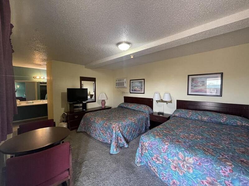 a hotel room with two beds and a table at Cherokee Inn in Cherokee