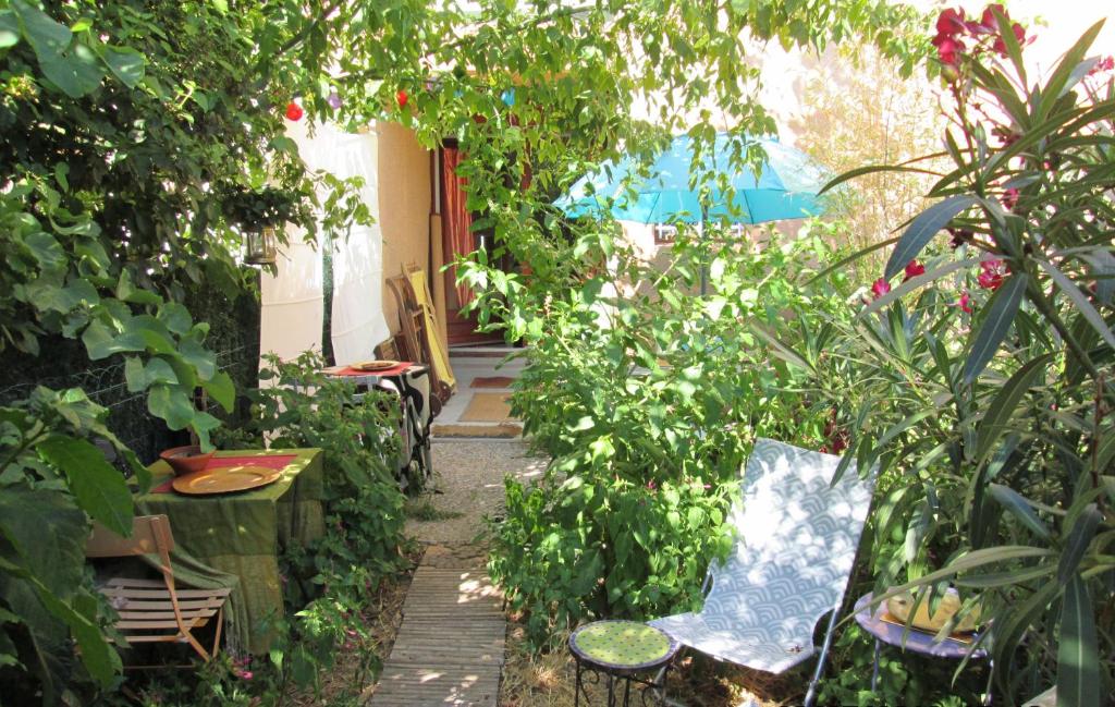 um jardim com plantas e cadeiras e um caminho em Joli Studio Avec Jardinet em Avignon
