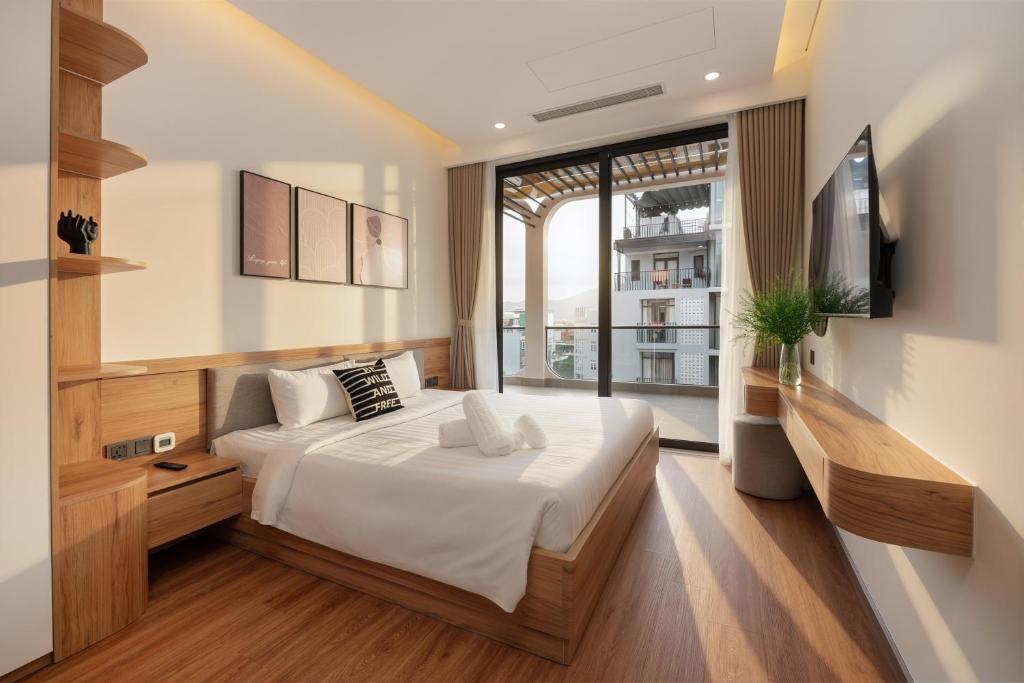 a bedroom with a large bed and a television at Grand Lux by BRIO in Danang
