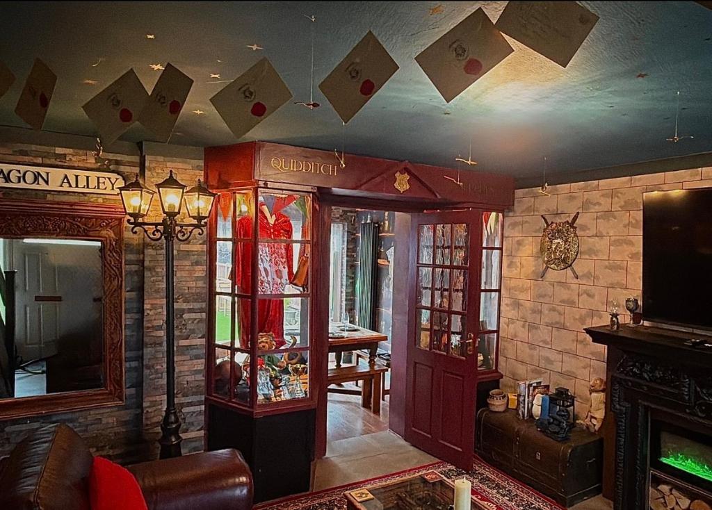 a living room with cards hanging from the ceiling at Quidditch Quarters Themed Property in Garston