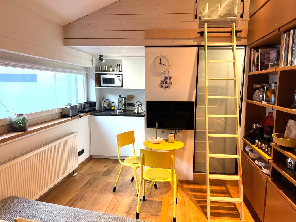 a small kitchen with a yellow table and a ladder at zons22 Tiny Loft in Historic Zons - between Cologne & Düsseldorf in Dormagen