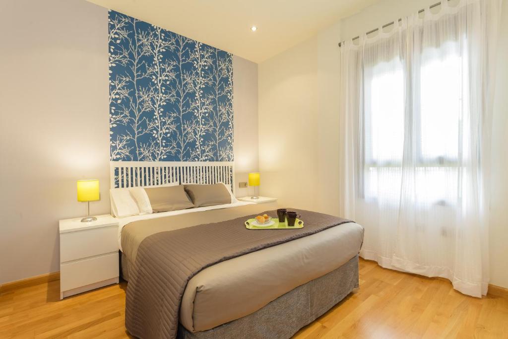 a bedroom with a bed with a blue and white wallpaper at Apartamento La PALMA free parking by Cadiz4Rentals in Cádiz