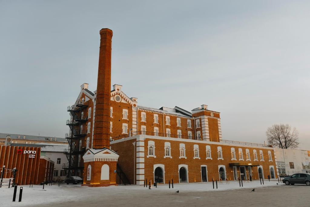 a large brick building with a chimney in front of it at Pana Unique Semey in Semey