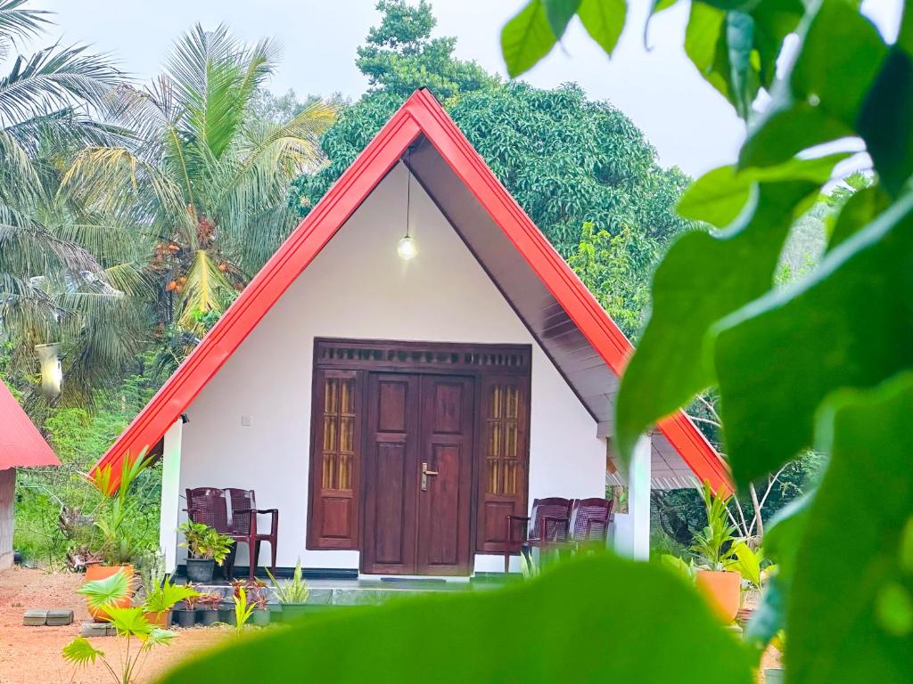 a small white house with a red roof at Sigiriya On Rock Villa in Sigiriya