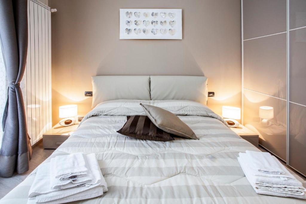 a bedroom with a large white bed with two lamps at Torino Suite in Turin