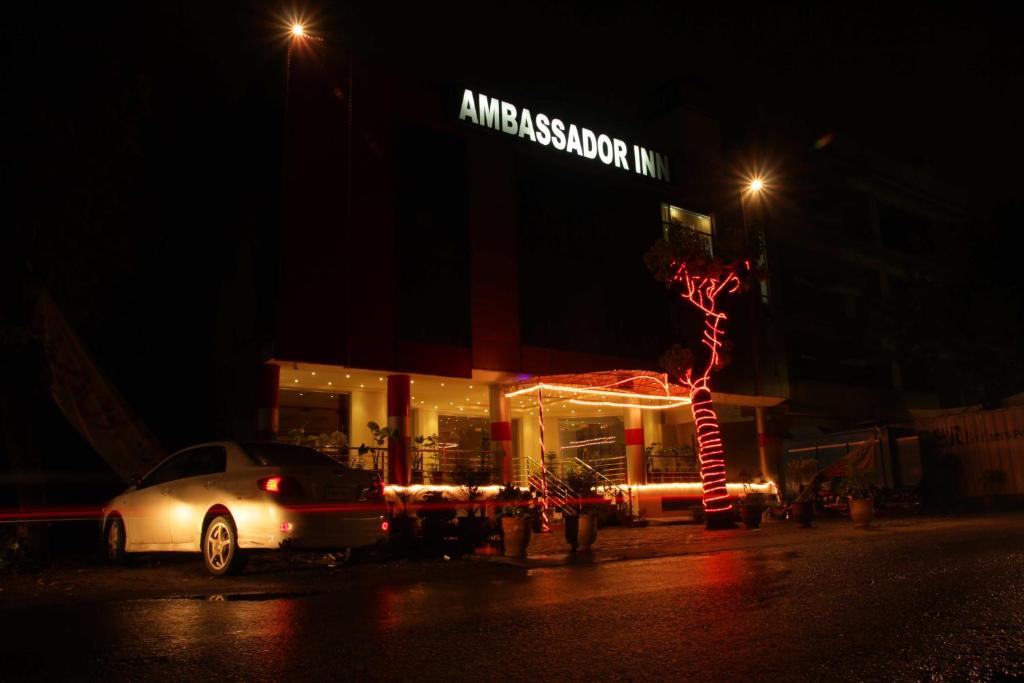 a car parked in front of a store at night at Ambassador Inn in Islamabad