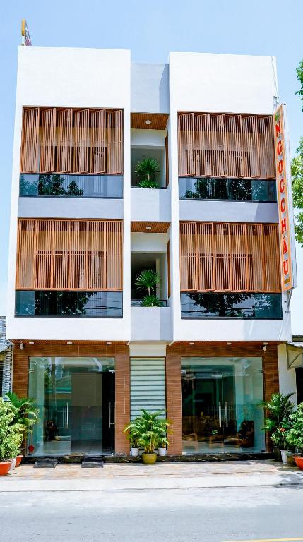 an apartment building with plants in front of it at Khách Sạn Ngọc Châu in Lấp Vò