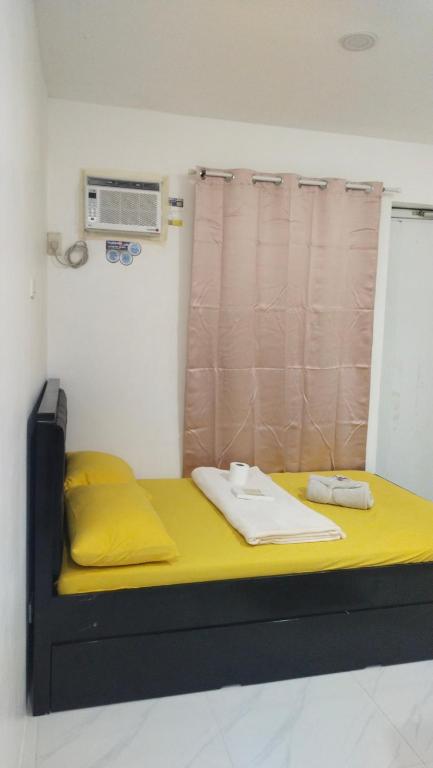 a bed in a room with a yellow mattress at Jessa's Transient Studio with Balcony in Masbate